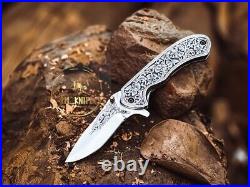 Handmade folding knife with hand engraved handle and blade